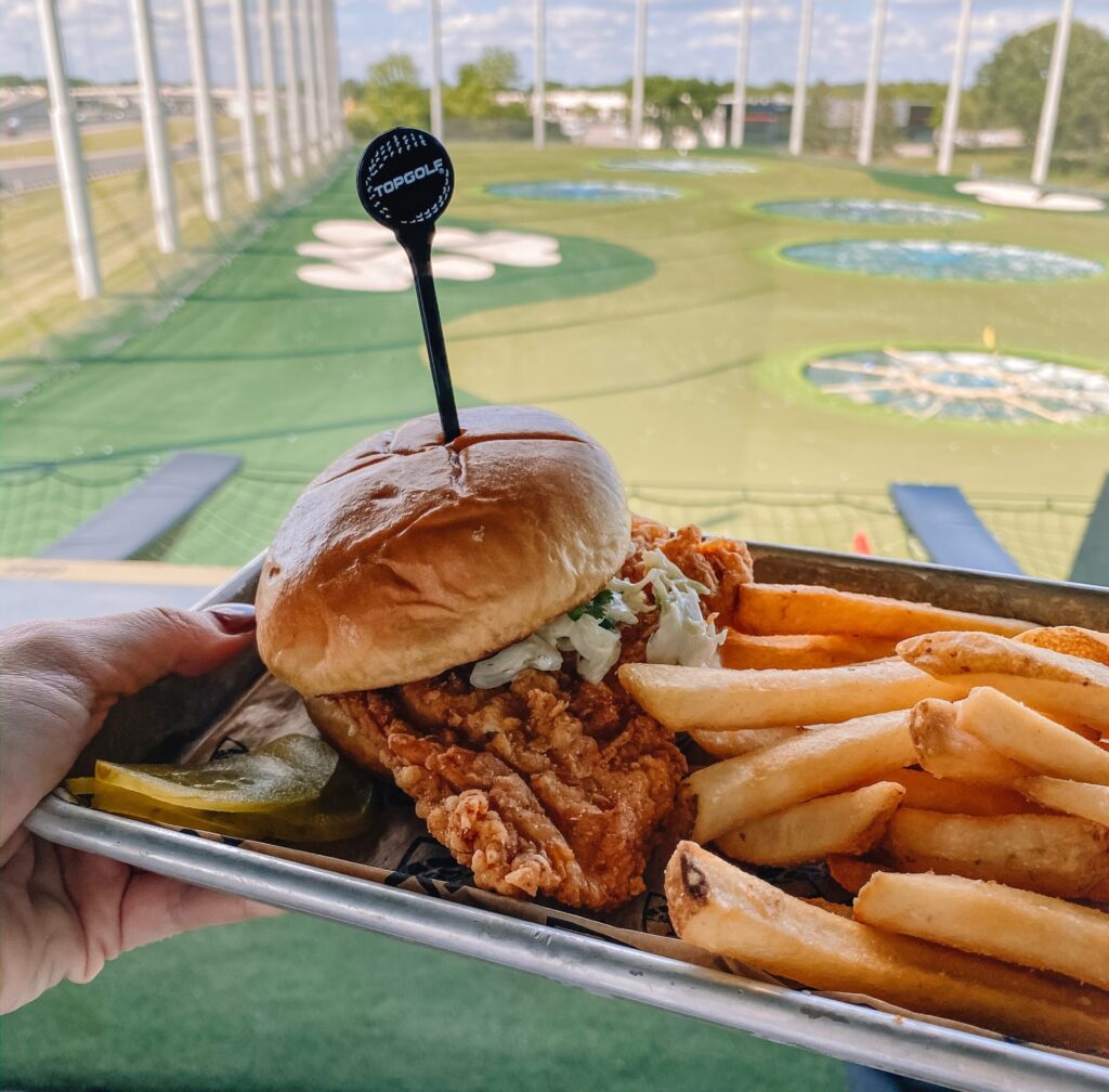 fried sandwich and fries with top golf in background