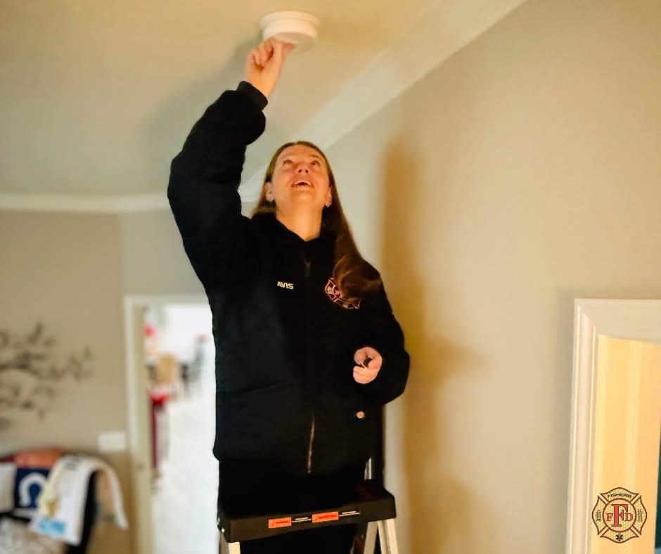 firefighter changing smoke alarm